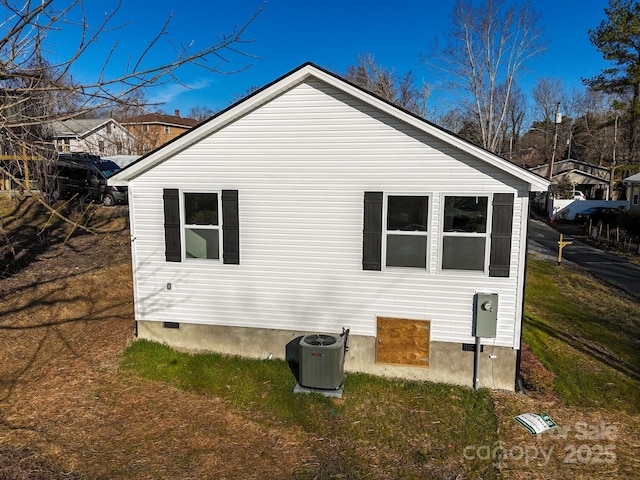 view of home's exterior with central AC and a yard