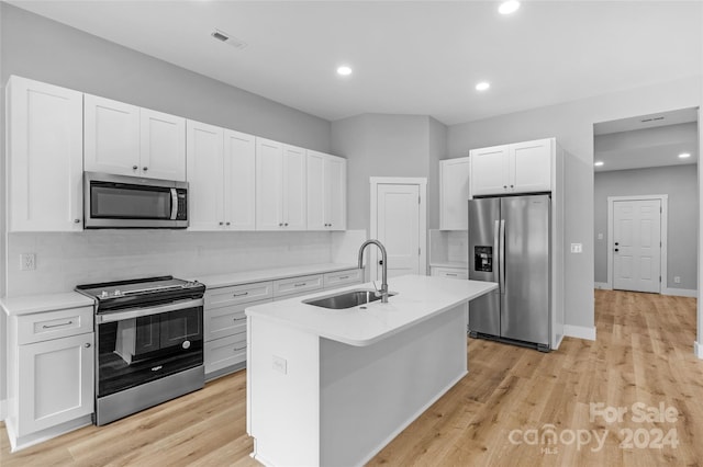 kitchen with light hardwood / wood-style flooring, stainless steel appliances, a center island with sink, and sink