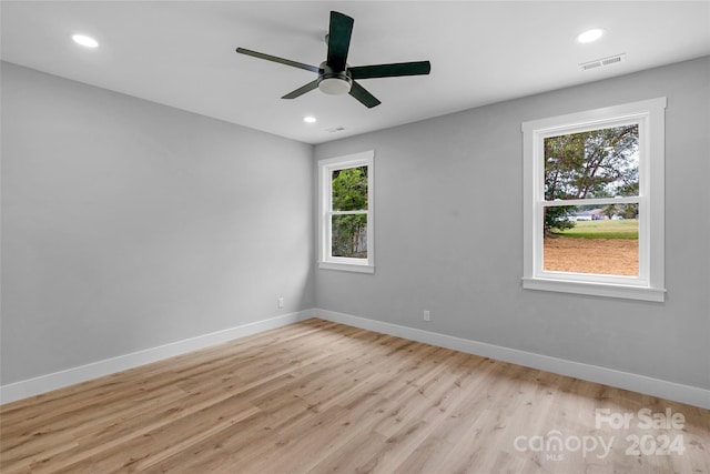 spare room with ceiling fan and light wood-type flooring