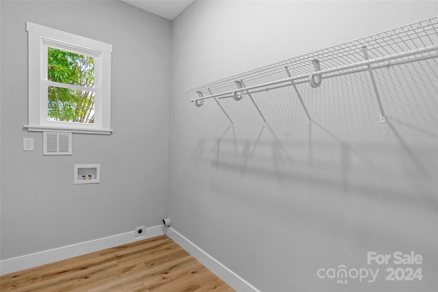 clothes washing area with washer hookup, hardwood / wood-style floors, and hookup for an electric dryer