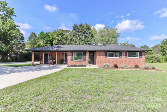 ranch-style house featuring a front lawn and a carport