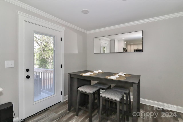 dining area with ornamental molding and dark hardwood / wood-style flooring