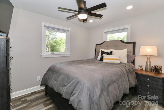 bedroom featuring multiple windows, ceiling fan, and dark hardwood / wood-style flooring