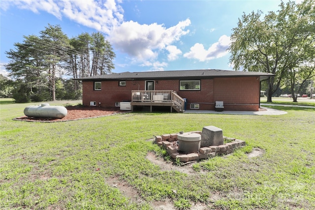 rear view of property featuring a lawn and a deck