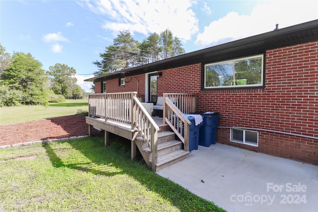 back of house featuring a yard, a wooden deck, and a patio area