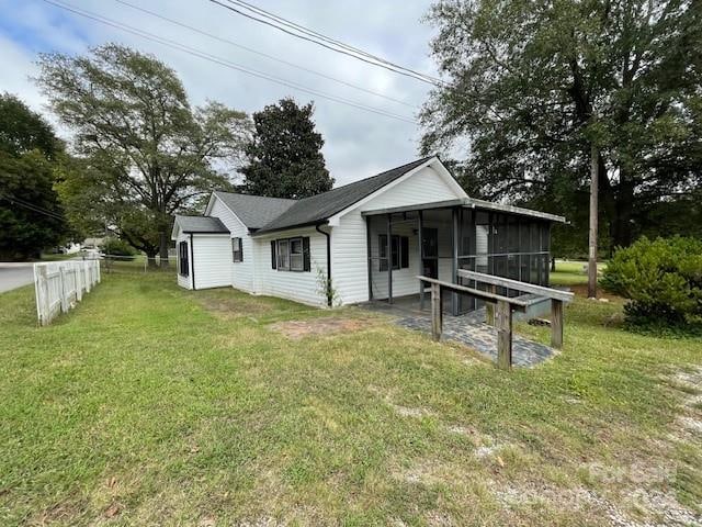 rear view of property with a yard and a sunroom