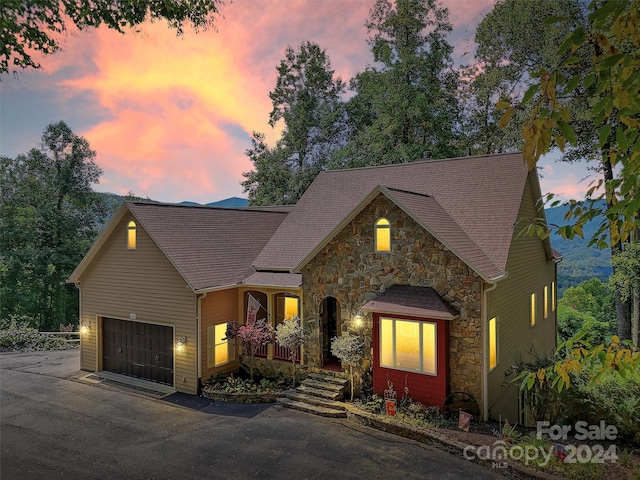 445 Equestrian Dr, Waynesville, NC 28786 - view of front of home with stone siding, a garage, driveway, and roof with shingles