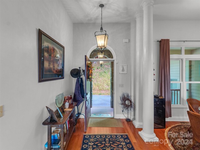 445 Equestrian Dr, Waynesville, NC 28786 - entrance foyer with decorative columns, wood finished floors, a chandelier, and baseboards