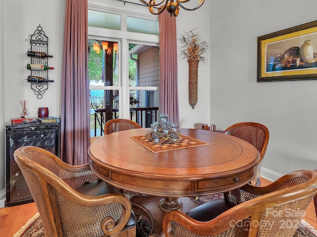 dining room with hardwood / wood-style floors and a chandelier