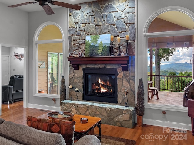 living room with a fireplace, a mountain view, and hardwood / wood-style floors