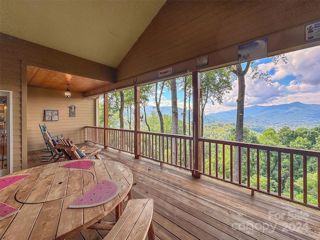 sunroom featuring vaulted ceiling and a mountain view