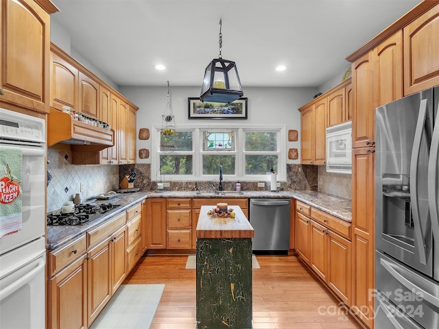 kitchen with a center island, light hardwood / wood-style floors, sink, and stainless steel appliances