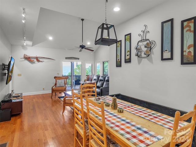 dining area featuring lofted ceiling, ceiling fan, and light wood-type flooring