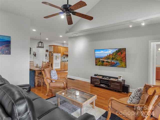 living room with light wood-type flooring, high vaulted ceiling, and ceiling fan