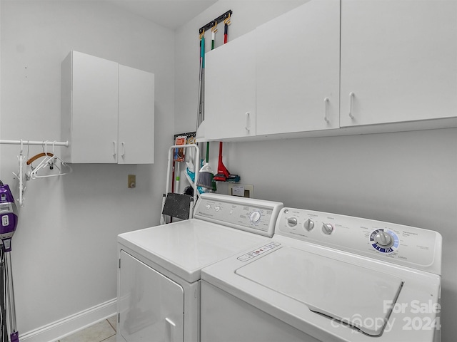 laundry room with light tile patterned flooring, separate washer and dryer, and cabinets