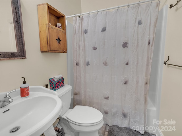 bathroom with a shower with curtain, sink, and toilet