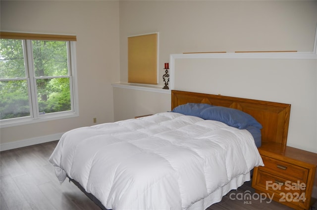 bedroom with dark hardwood / wood-style flooring