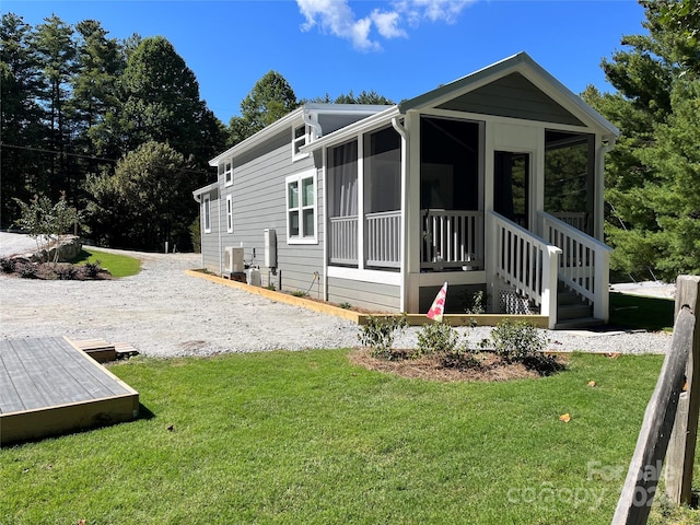 view of home's exterior featuring a sunroom and a yard