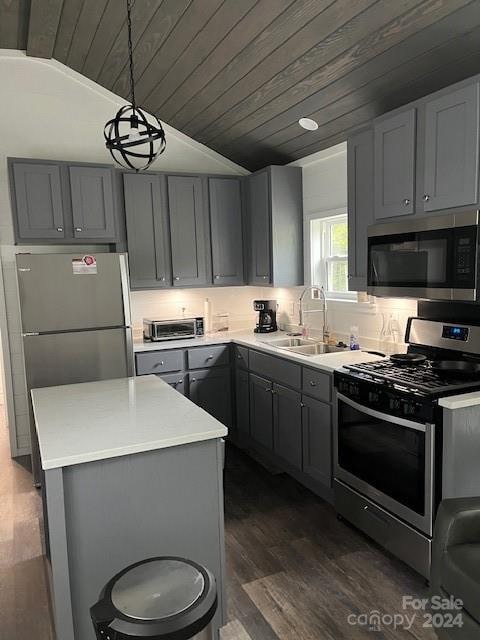 kitchen featuring wood ceiling, sink, vaulted ceiling, stainless steel appliances, and decorative light fixtures