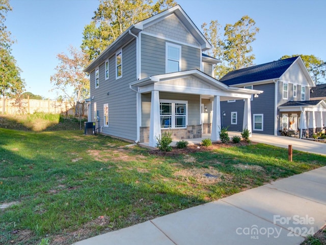 view of front of home featuring central AC unit, concrete driveway, fence, a porch, and a front yard