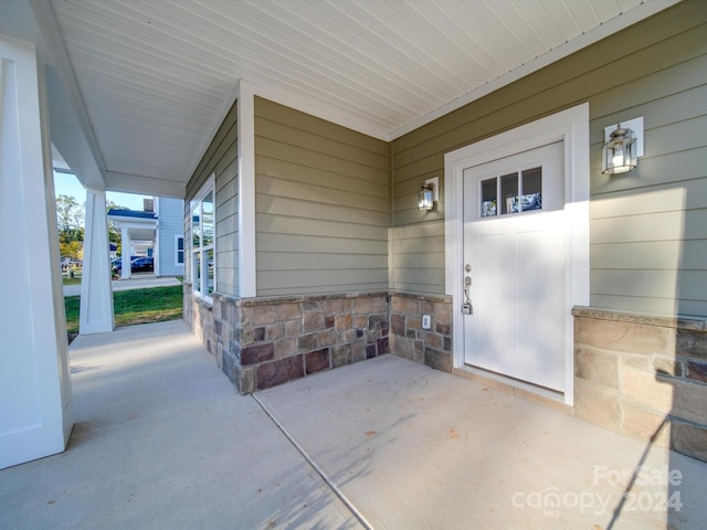 view of exterior entry featuring covered porch
