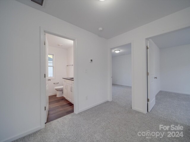 unfurnished bedroom featuring visible vents, carpet flooring, baseboards, and connected bathroom
