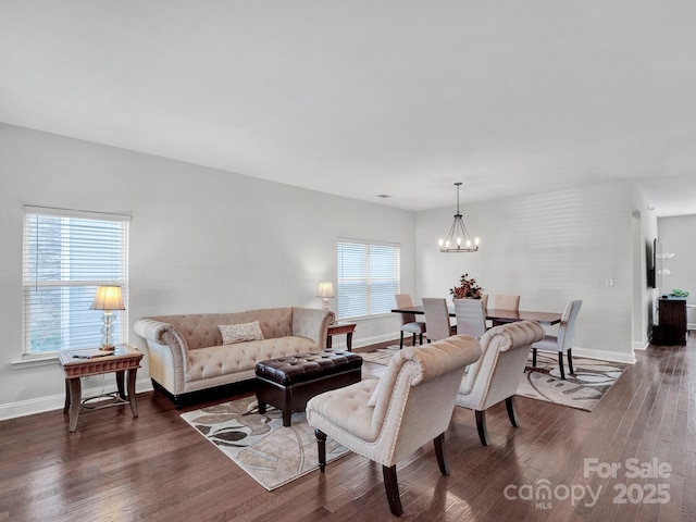 living room featuring dark hardwood / wood-style flooring, plenty of natural light, and a notable chandelier