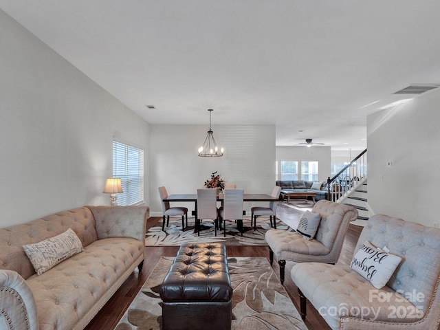 living room featuring ceiling fan with notable chandelier and light hardwood / wood-style floors