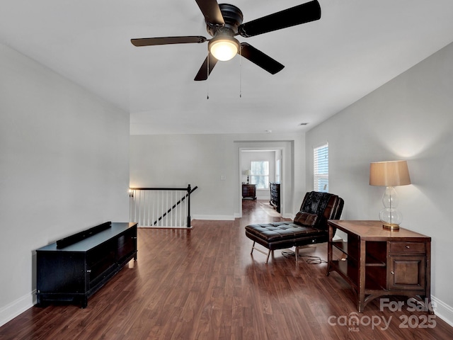 living area with ceiling fan and dark hardwood / wood-style flooring