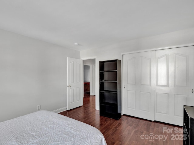 bedroom with dark wood-type flooring and a closet