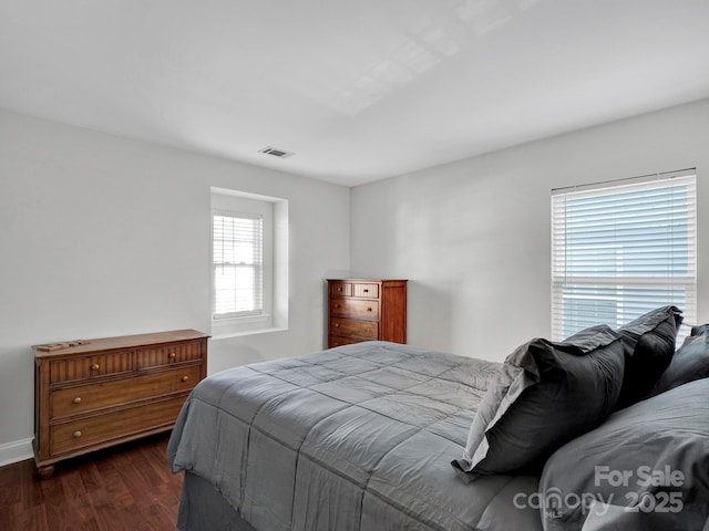 bedroom with dark hardwood / wood-style flooring