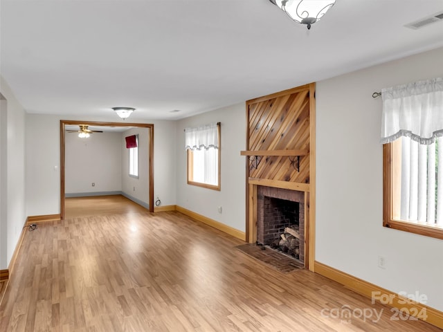 unfurnished living room featuring light wood-type flooring, a fireplace, and ceiling fan