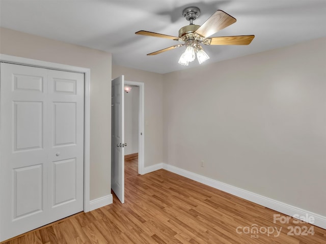 unfurnished bedroom featuring ceiling fan, light hardwood / wood-style flooring, and a closet