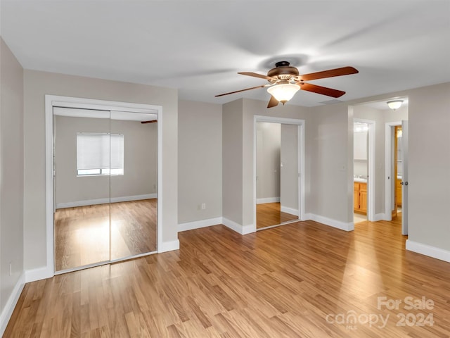 unfurnished bedroom with light wood-type flooring, ceiling fan, and a closet