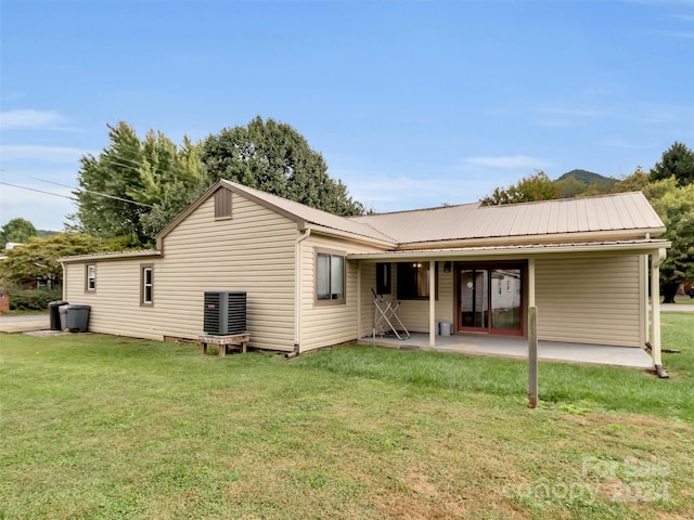 rear view of property featuring a lawn and a patio area