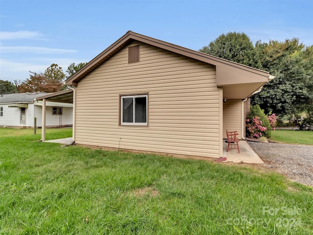 view of side of property with a lawn and a patio