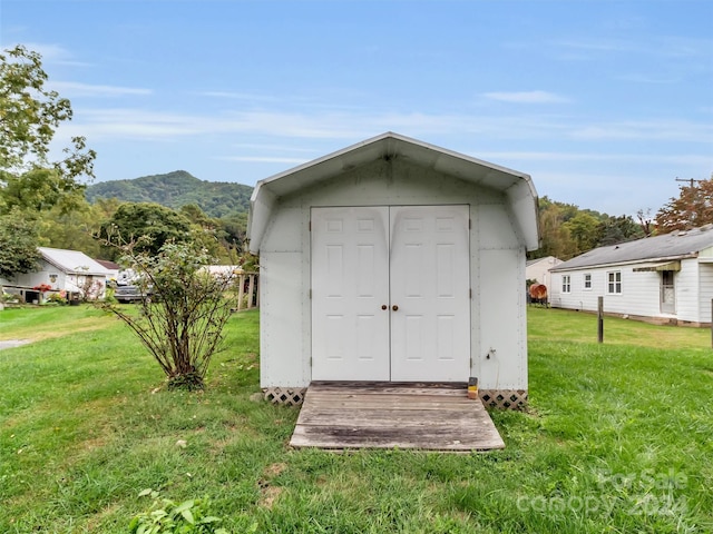 view of outdoor structure featuring a lawn and a mountain view