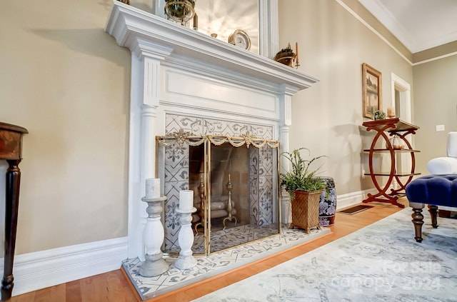 sitting room with a premium fireplace, crown molding, and hardwood / wood-style flooring