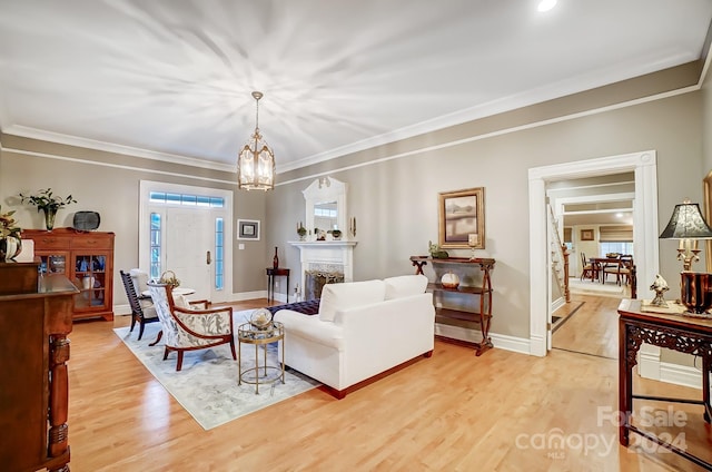 living room with ornamental molding, light hardwood / wood-style floors, and plenty of natural light