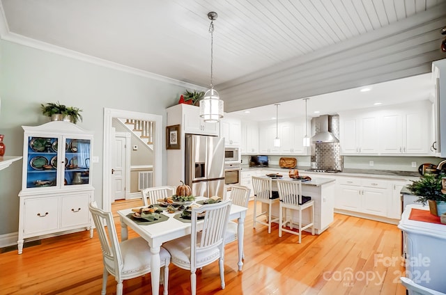 dining area with light hardwood / wood-style flooring, wooden ceiling, and crown molding