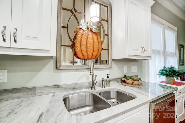 kitchen with stainless steel dishwasher, sink, white cabinetry, and light stone countertops