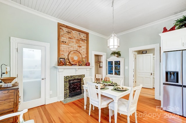 dining room with wood ceiling, light hardwood / wood-style flooring, ornamental molding, sink, and a brick fireplace