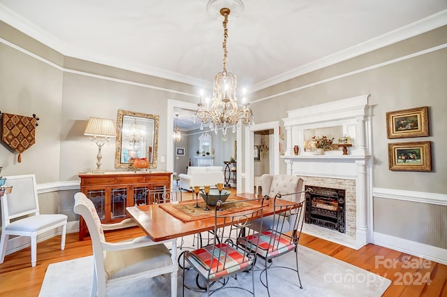 dining area featuring ornamental molding, a chandelier, and light hardwood / wood-style floors