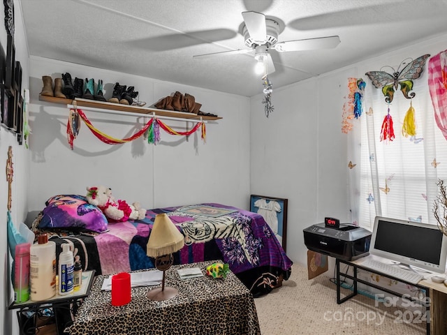 carpeted bedroom featuring ceiling fan and a textured ceiling