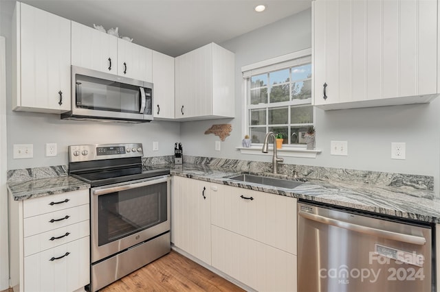 kitchen featuring light hardwood / wood-style flooring, appliances with stainless steel finishes, sink, and white cabinetry