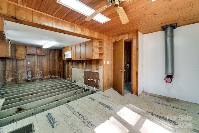 kitchen with ceiling fan and wood walls