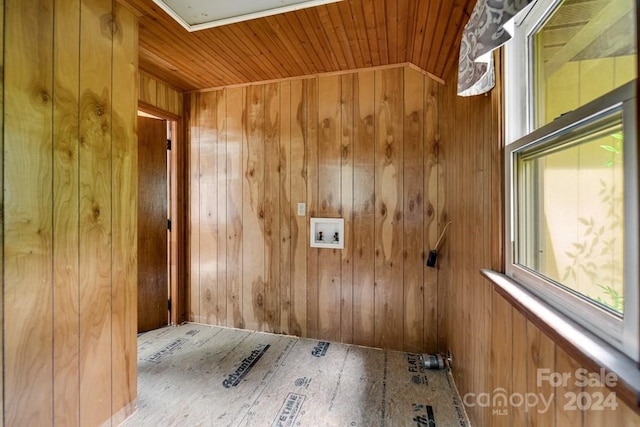 clothes washing area with wooden walls, wood ceiling, and washer hookup