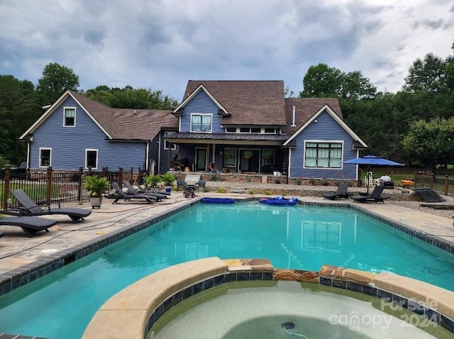 view of swimming pool with a patio and an in ground hot tub