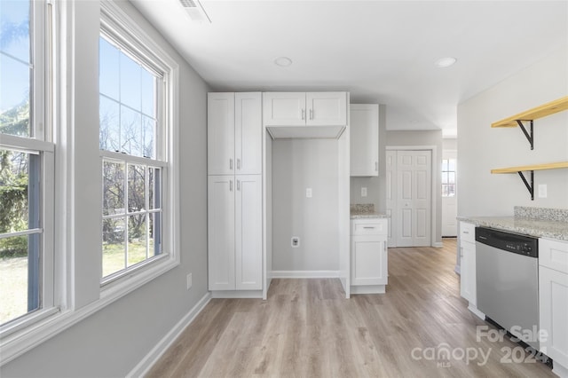 kitchen with a wealth of natural light, dishwasher, light stone counters, and white cabinets