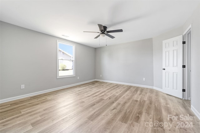 empty room with ceiling fan and light hardwood / wood-style flooring